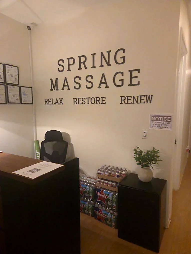 The Spring Massage reception wall lettered SPRING MASSAGE — RELAX RESTORE RENEW, with framed certificates alongside